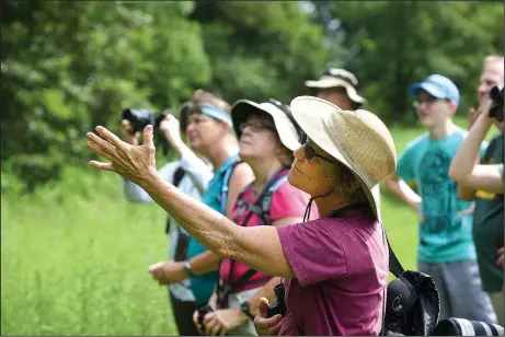  ?? NWA Democrat-Gazette/FLIP PUTTHOFF ?? Prairie pedestrian­s admire bird life at the Chesney Prairie. The Northwest Arkansas Audubon Society hosted a trip to the area July 8.