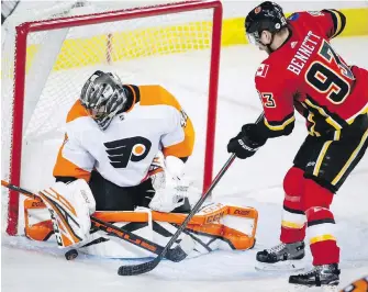  ??  ?? Flyers goalie Anthony Stolarz blocks a shot from Flames forward Sam Bennett during third-period action in Calgary on Wednesday.