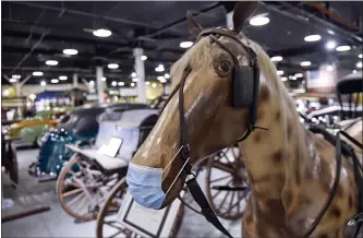  ?? BEN HASTY — MEDIANEWS GROUP ?? A COVID-complying masked plastic horse is part of a display at the Boyertown Museum of Historic Vehicles earlier in 2021. The museum in the former home of the Boyertown Auto Body Works has reopened to guests but many similar places have not, but they want to.