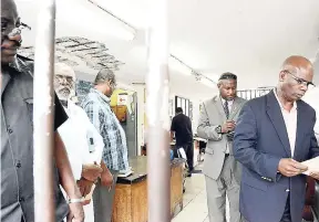  ?? FILE ?? Custos of Kingston Steadman Fuller (right) leading a tour of the lock-up at the Kingston Central Police Station.