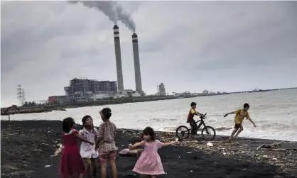  ??  ?? Children play by the beach near a coal power plant in Java. Photograph: Kemal Jufri/Greenpeace