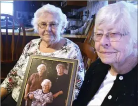  ?? JIM MARTIN — ERIE TIMES-NEWS VIA AP ?? In a photo, sisters Susie Armstrong, 83, and Shirley Clark, 88, pose for a photo at Armstrong’s home in Stoneboro, Mercer County, Pa., holding a photo of themselves with their mother, Grace Vath, seated. The sisters have been searching for their older...