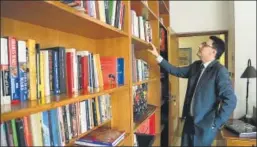  ??  ?? Ambassador of France to India, Alexandre Ziegler, browsing through his personal bookshelve­s