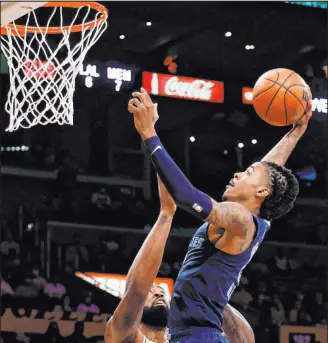  ?? Ringo H.W. Chiu The Associated Press ?? Grizzlies guard Ja Morant soars to the basket over Lakers center Deandre Jordan in the first half of Los Angeles’ 121-118 win Sunday at Staples Center.