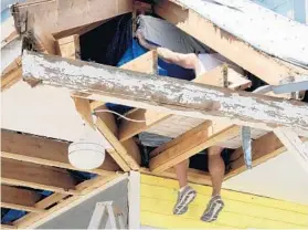 ?? TAIMY ALVAREZ/STAFF PHOTOGRAPH­ER ?? On Sept, 15, Bill Thompson, a retiree from Palm Beach County, nailed a tarp onto the roof of his home on Little Torch Key. After inspection­s are over, the focus turns to settlement­s and repairs.