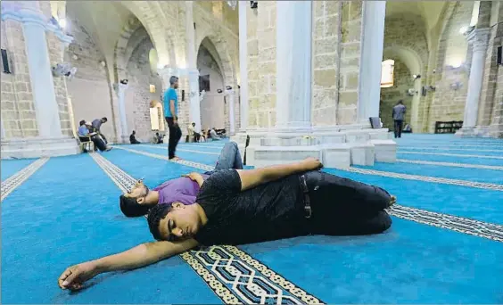  ?? MOHAMMED ABED / AFP / ARCHIVO ?? Las siestas son habituales durante el Ramadán, como la de estos jóvenes
palestinos en la ciudad de Gaza. Abajo una mujer rezando