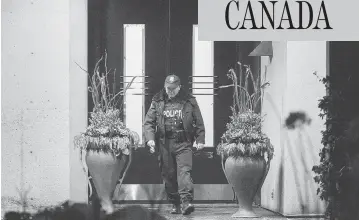  ?? PETER J THOMPSON / NATIONAL POST ?? An officer leaves the north Toronto home of philanthro­pists Honey and Barry Sherman. Both were found dead.