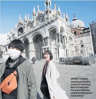  ??  ?? CRISIS: Tourists wearing protective masks in Venice as Italy has become the worst affected country in Europe for coronaviru­s