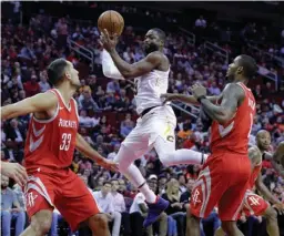  ?? Associated Press ?? Cleveland Cavaliers guard Dwyane Wade (9) goes up to pass between Houston Rockets forward Ryan Anderson (33) and forward Trevor Ariza (1) during the first half of an NBA basketball game Thursday in Houston.