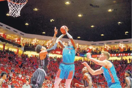  ?? ROBERTO E. ROSALES/JOURNAL ?? New Mexico’s Corey Manigault puts up a shot over New Mexico State’s Eli Chuha during Saturday’s first half. Manigault scored 22 points for the Lobos, who were chasing for most of the game and finally fell just short to the Aggies.