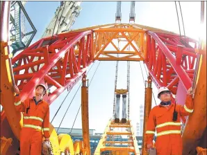  ?? XUE ZHOU / FOR CHINA DAILY ?? Shenhua workers install equipment at a coal-to-liquids project in the Ningxia Hui autonomous region.