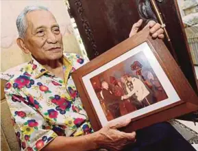  ?? PIC BY MOHD AZREN JAMALUDIN ?? Datuk Yusof Malim Kuning holding an old photo of himself at his home in Kota Tinggi recently.
