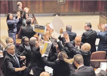  ?? Ariel Schalit Pool Photo ?? THIRTEEN MEMBERS of Israel’s parliament protested during Mike Pence’s speech, some holding signs reading, “Jerusalem is the capital of Palestine.” Security personnel removed the protesters from the room.