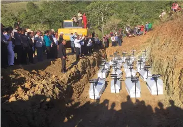  ?? — AFP photo ?? Caskets containing the remains of unidentifi­ed flash flood victims are buried in a mass grave in Sentani.