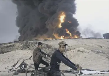  ??  ?? 0 An oil well burns in Al Qayyarah, releasing pollutants that can cause serious health problems.