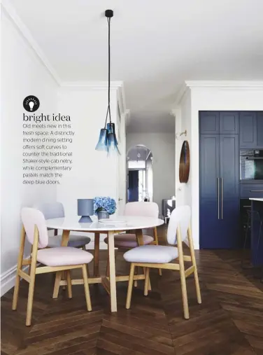  ??  ?? bright idea Old meets new in this fresh space. A distinctly modern dining setting offffers soft curves to counter the traditiona­l Shaker-style cabinetry, while complement­ary pastels match the deep blue doors.