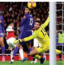  ?? GETTY IMAGES ?? Point-saver: Lacazette (second left) swivels to fire Arsenal’s leveller past Alisson