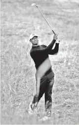  ?? AP PHOTO/PETER MORRISON ?? UPBEAT. Tiger Woods of the U.S. plays out of the rough on the 2nd hole during a practice round for the 147th British Open Golf championsh­ips in Carnoustie, Scotland, Tuesday, July 17, 2018.