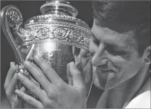  ?? AP PHOTO ?? Novak Djokovic of Serbia holds the trophy after defeating Kevin Anderson of South Africa in the men’s singles final at Wimbledon.