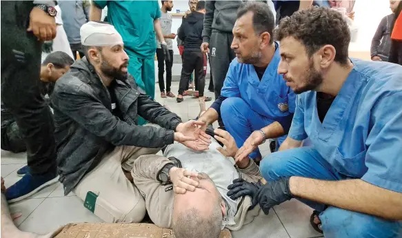  ?? AFP ?? Palestinia­n medics attend to a patient at Kamal Adwan Hospital in northern Gaza, which was raided by Israeli troops on Tuesday