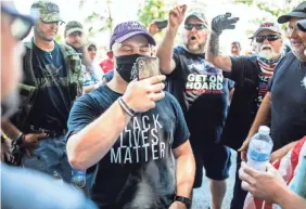  ?? SEAN SIMMERS/PENNLIVE.COM ?? Trent Somes, who went to visit the grave of an ancestor at Gettysburg National Cemetery, is surrounded by militia members, telling him to leave the park because he was wearing a Black Lives Matter T-shirt.
