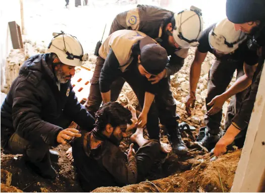  ?? PHOTO D’ARCHIVES AFP ?? Des Casques blancs viennent en aide à un homme blessé lors de raids à Deraa sur cette photo prise le 17 novembre dernier.