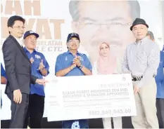  ??  ?? Musa (middle) witnesses a payment made to Sabah Forest Industries Sdn Bhd.