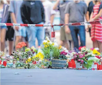  ?? FOTO: NICOLAS ARMER/DPA ?? Trauer am Tatort in Würzburg: In der Innenstadt hat ein psychisch auffällige­r und womöglich islamistis­ch radikalisi­erter Somalier drei Menschen ermordet.