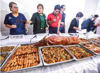  ?? (Mark Balmores) ?? Local hog farmers, together with officials of the Quezon City government, show different kinds of pork dishes during a press conference at the Quezon Memorial Circle, on February 22, 2024.