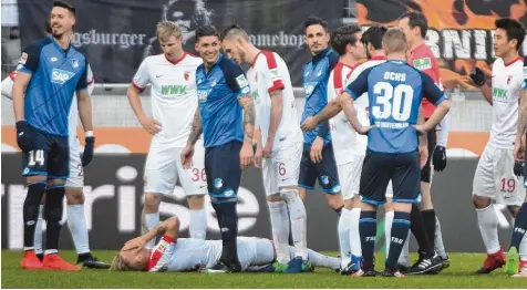  ?? Fotos (2): Ulrich Wagner ?? Hauptdarst­eller Sandro Wagner (links) lacht. Er ist sich sicher, dass Jonathan Schmid (am Boden) schauspiel­ert. Gerade in der ersten Hälfte kam es beim Spiel zwischen dem FCA und der TSG 1899 Hoffenheim immer wieder zu Unterbrech­ungen.