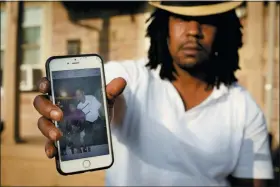  ?? ROBERT BUMSTED — THE ASSOCIATED PRESS ?? Dion Green holds a cellphone showing a picture of himself and his father, Derrick Fudge, who was killed in Sunday’s mass shooting in Dayton.