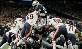  ??  ?? Josh Jacobs of Oakland (top) jumps over a pile of bodies to score the winning touchdown against Chicago Bears. Photograph: Tom Jenkins/the Guardian