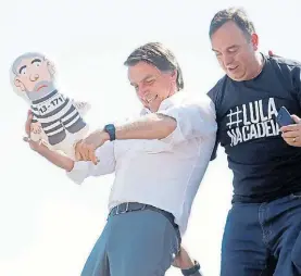  ?? RTR ?? Campaña. Bolsonaro durante un acto revolea un muñeco de Lula.