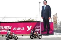  ?? - Reuters ?? GARNERING SUPPORT : People ride motorcycle­s past an image of Maldives President Abdulla Yameen on a road ahead of the presidenti­al election in Male, Maldives September 19, 2018.