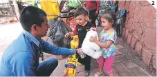  ??  ?? (1) Niños y niñas de la localidad fueron beneficiad­os. (2) El periodista Elvis Mendoza mientras dona juguetes a varios niños.