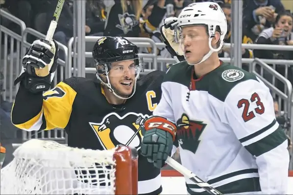  ?? Pittsburgh Post-Gazette ?? Sidney Crosby celebrates a goal by Dominik Simon in the third period of Thursday’s 6-3 win against the Wild at PPG Paints Arena.