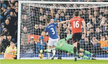  ??  ?? Everton’s English defender Leighton Baines (left) scores his penalty past the diving Manchester United’s Spanish goalkeeper David de Gea during the English Premier League football match between Everton and Manchester United at Goodison Park in...