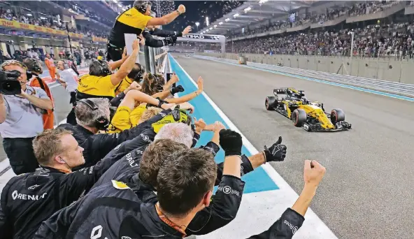  ?? FOTO: RENAULT ?? Das Renault-Team bejubelt Nico Hülkenberg in Abu Dhabi bei der Zieleinfah­rt.