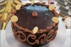  ?? PHOTO BY EMILY RYAN ?? Indulge in a three-layer praline chocolate cake from Strawberry Bakery.