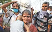  ?? REUTERS ?? A MIGRANT WORKER holding her baby cries after she missed out on receiving free food outside Howrah railway station after India ordered a 21-day nationwide lockdown to limit the spread of coronaviru­s disease, in Kolkata, India, March 25.