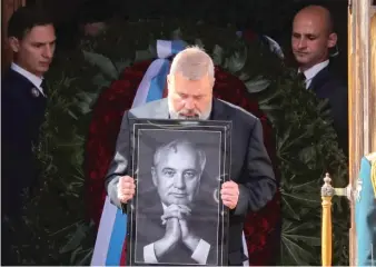  ?? ?? Nobel Peace Prize winner Dmitry Muratov carries a portrait of Gorbachev at his public funeral Saturday.