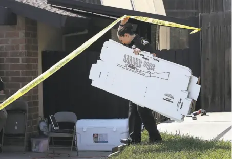  ?? Rich Pedroncell­i / Associated Press ?? A Sacramento County sheriff's deputy carries evidence boxes into the Citrus Heights home of slaying suspect Joseph DeAngelo.