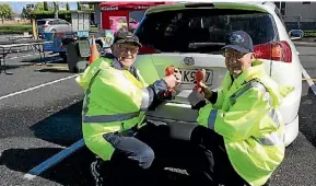  ?? JANE MATTHEWS/STUFF ?? Patrol volunteers Murray Fawcett and Alan Manning were more than happy to give the Stratford community safer registrati­on plates.