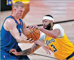  ?? MARK J. TERRILL/AP ?? Nuggets’ Mason Plumlee, left, and Lakers’ Anthony Davis compete for control Friday.