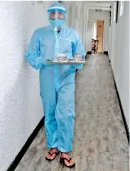  ??  ?? At the Bandarawel­a Orient Hotel, a hotel employee wore PPE to ensure they adhere to health guidelines