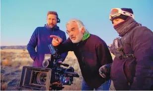  ??  ?? Director and co-writer Paul Greengrass, center, with crew members on the set of “News of the World.”