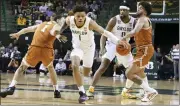  ?? ROD AYDELOTTE — WACO TRIBUNE-HERALD VIA AP ?? Baylor guard Keyonte George (1) loses the ball while driving through Texas forward Dylan Disu (1) and Timmy Allen in the first half of Saturday’s game in Waco, Texas.