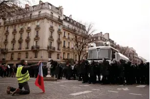  ?? (Christian Hartmann/Reuters) ?? A ‘YELLOW-VEST’ protester faces off against French police yesterday near the Arc de Triomphe in Paris.