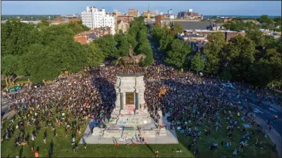  ?? The Associated Press ?? RICHMOND: A group of protesters gather around the statue of Confederat­e General Robert E. Lee on Monument Avenue on June 2 near downtown Richmond, Va. Virginia Gov. Ralph Northam announced plans Thursday for the removal of the statue.