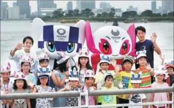  ?? ISSEI KATO / REUTERS ?? Tokyo 2020 Olympic Games mascot Miraitowa and Paralympic mascot Someity wave with Japan’s Paralympic long-jumper Hajimu Ashida, karateka Kiyo Shimkizu and children during the official unveiling at Odaiba Marine Park in Tokyo on Sunday.